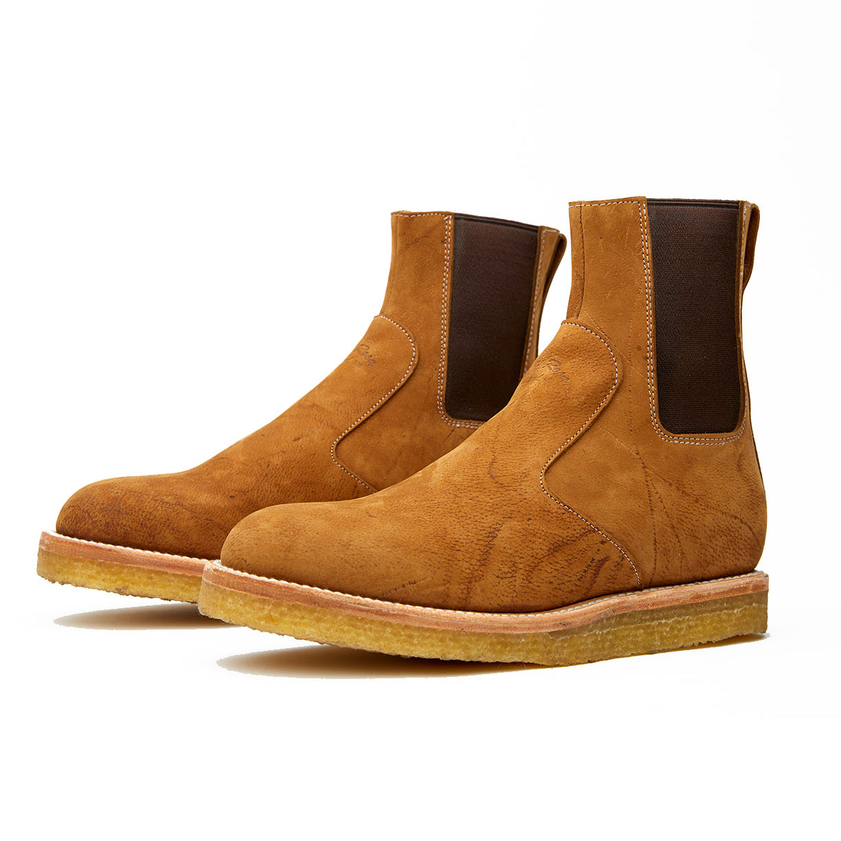 A pair of Santa Rosa Brand Stamford boots in tan suede featuring a natural crepe outsole and crafted with veg tan leather, all set against a white background.